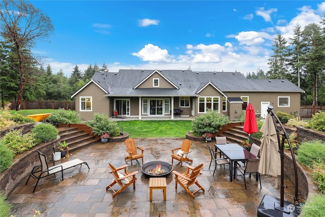 back of property featuring a patio and an outdoor fire pit