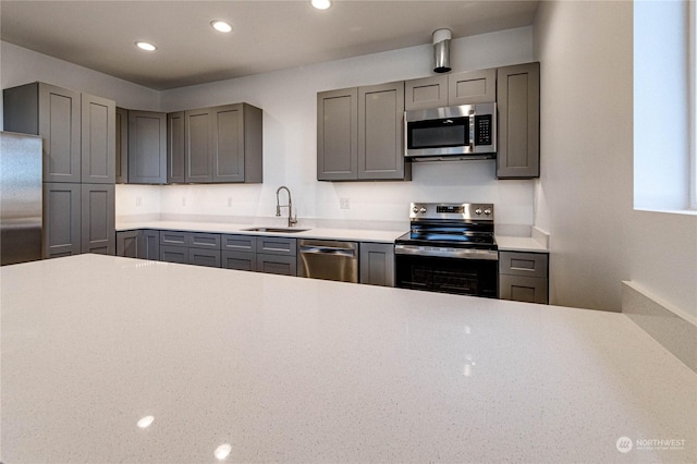 kitchen featuring stainless steel appliances, gray cabinets, and sink