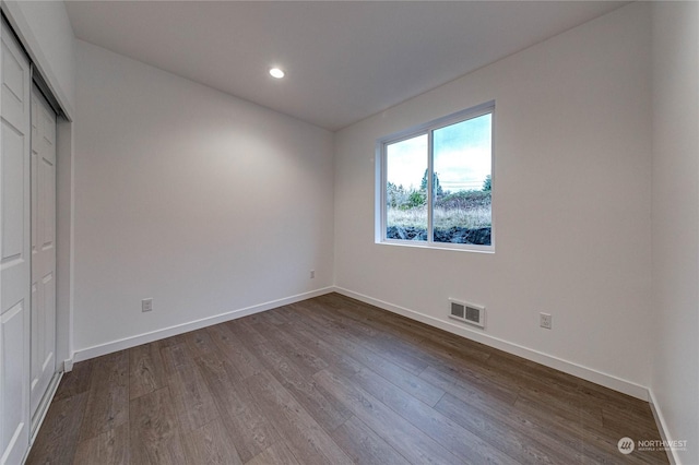 unfurnished bedroom with hardwood / wood-style floors and a closet