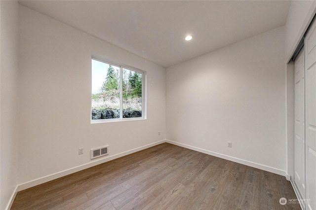 unfurnished bedroom featuring wood-type flooring and a closet