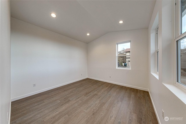 unfurnished room featuring hardwood / wood-style flooring and lofted ceiling