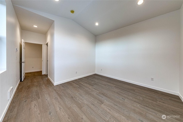 empty room featuring lofted ceiling and wood-type flooring