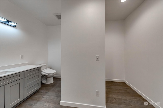 bathroom featuring hardwood / wood-style flooring, vanity, and toilet