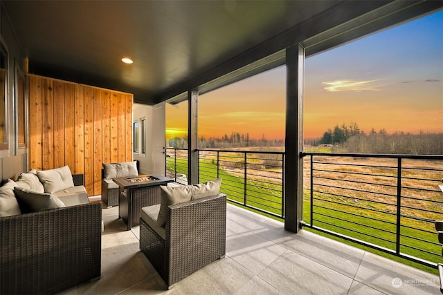 balcony at dusk with an outdoor living space with a fire pit