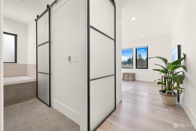 hallway featuring light hardwood / wood-style floors and a barn door