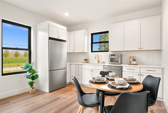 kitchen featuring tasteful backsplash, sink, white cabinets, and appliances with stainless steel finishes