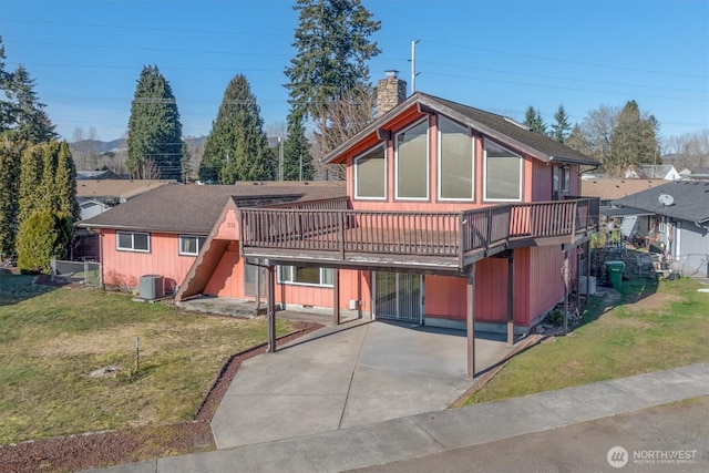 view of front of house with central AC, a wooden deck, and a front lawn