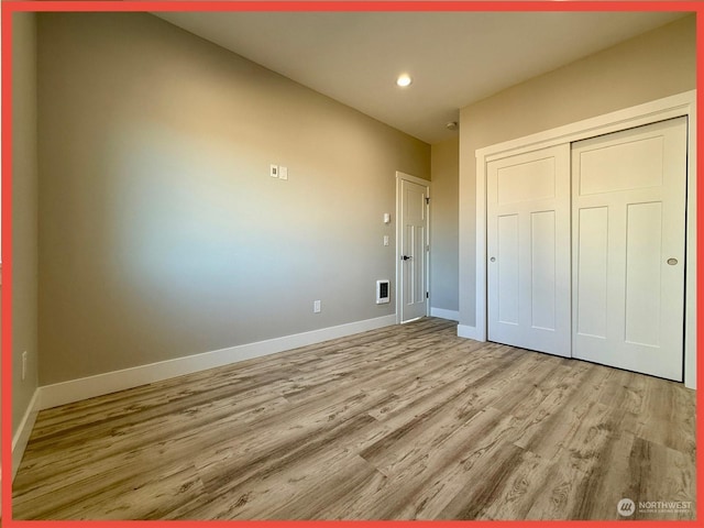 unfurnished bedroom with light hardwood / wood-style floors and a closet