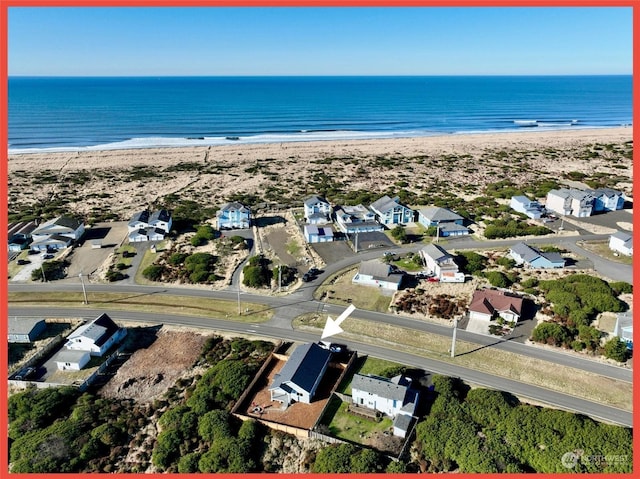 bird's eye view with a water view and a beach view