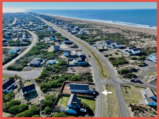 drone / aerial view with a water view and a beach view