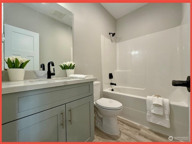 full bathroom with hardwood / wood-style flooring, vanity, toilet, and shower / bathing tub combination