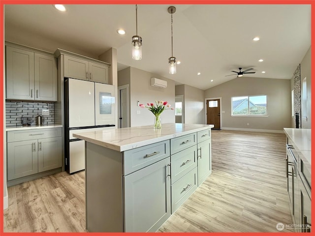 kitchen featuring hanging light fixtures, light hardwood / wood-style floors, an AC wall unit, and white refrigerator