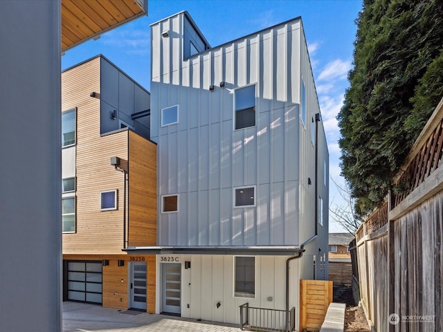 view of front of house featuring board and batten siding and fence