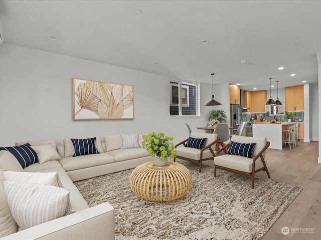 living area with recessed lighting and light wood-style flooring