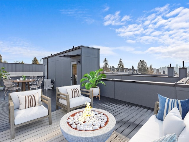 wooden deck featuring outdoor dining area and an outdoor living space with a fire pit