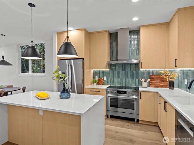 kitchen with light brown cabinets, appliances with stainless steel finishes, light countertops, and wall chimney exhaust hood