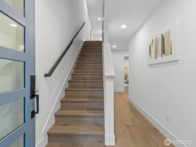 stairway with recessed lighting, baseboards, and wood finished floors