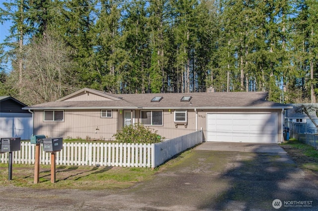 ranch-style house with a fenced front yard, driveway, and a garage