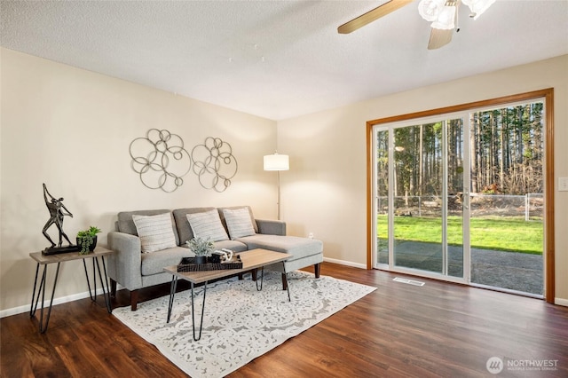 living room featuring visible vents, baseboards, and wood finished floors