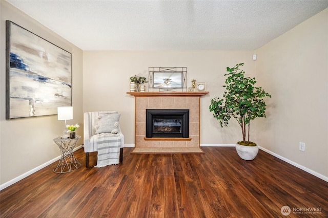 unfurnished room featuring baseboards, wood finished floors, and a fireplace