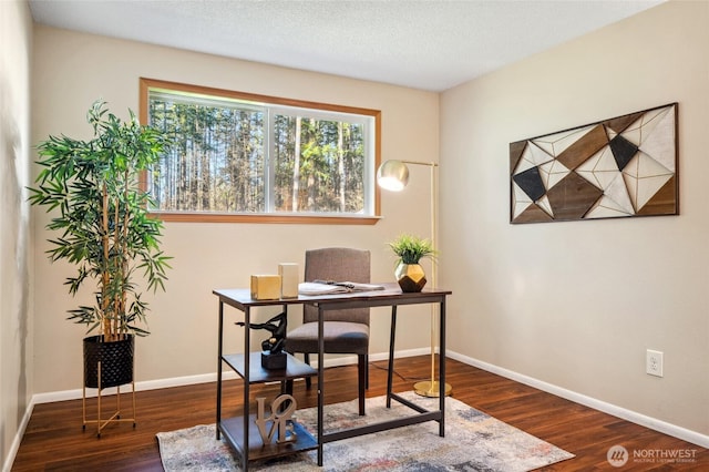 office area with a textured ceiling, baseboards, and wood finished floors