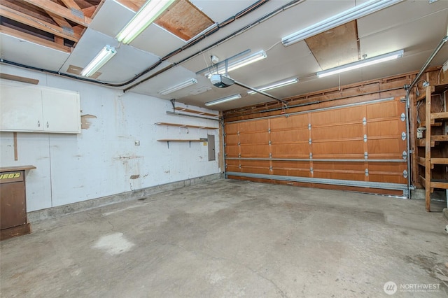 garage with electric panel and a garage door opener