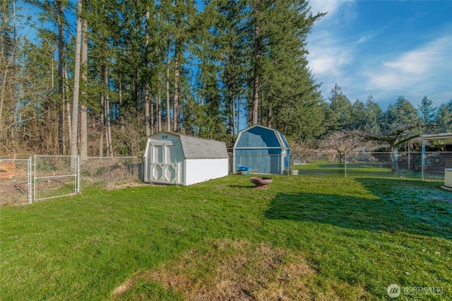 view of yard with an outbuilding, a storage shed, a fenced backyard, and a gate