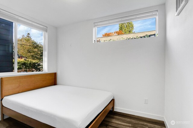 bedroom with dark wood-type flooring