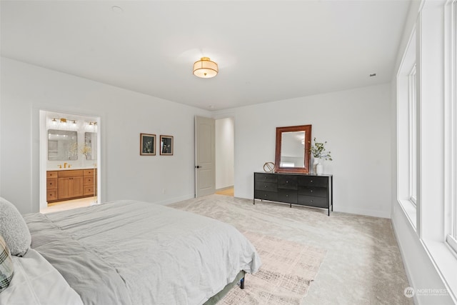 bedroom with connected bathroom and light colored carpet