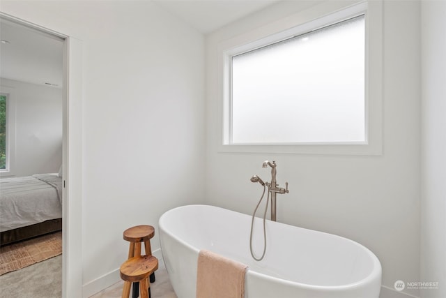 bathroom featuring a bath and plenty of natural light