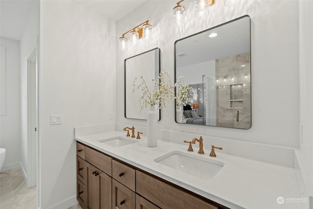 bathroom featuring a shower with door and vanity