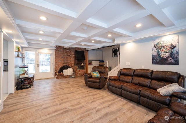 living room with beamed ceiling, a fireplace, coffered ceiling, and light hardwood / wood-style flooring