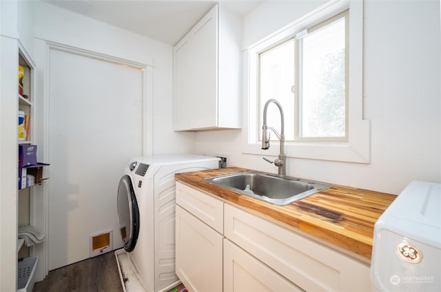 clothes washing area featuring cabinets, washing machine and dryer, sink, and dark wood-type flooring