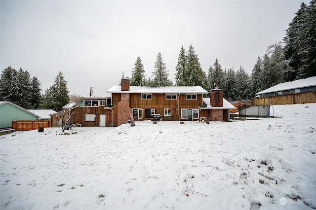 view of snow covered rear of property