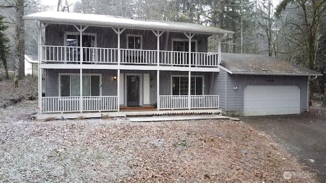 view of front of home with a garage, a balcony, and covered porch