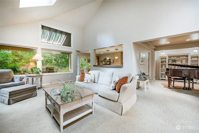 living room with a skylight, high vaulted ceiling, and carpet