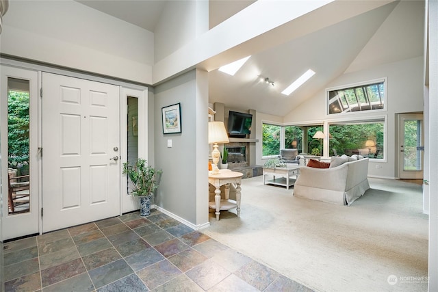 foyer featuring a skylight, a healthy amount of sunlight, and a high ceiling