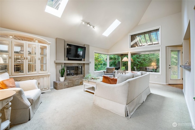 living room with a skylight, plenty of natural light, and a tiled fireplace