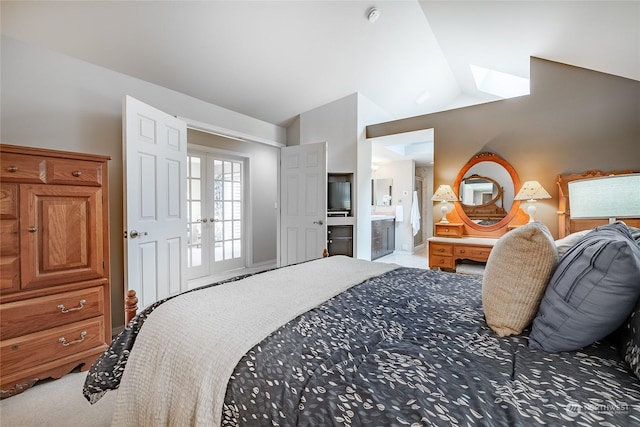 bedroom featuring french doors, lofted ceiling, ensuite bathroom, and carpet