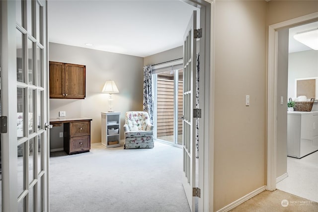 sitting room with washer / dryer and light colored carpet