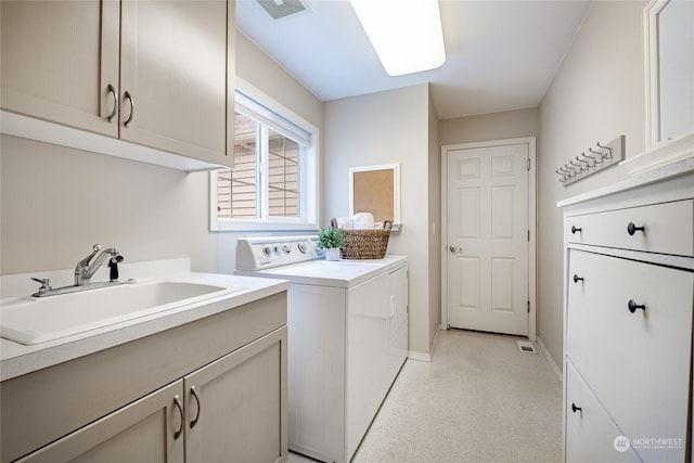 washroom with cabinets, sink, and independent washer and dryer