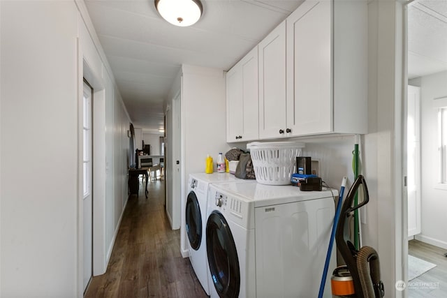 clothes washing area with cabinets, dark hardwood / wood-style floors, and washing machine and dryer