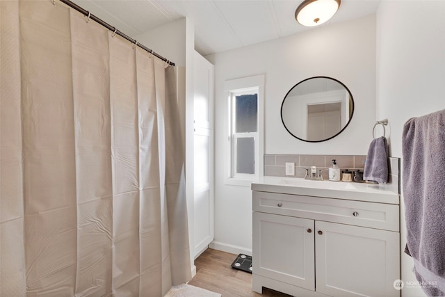 bathroom featuring hardwood / wood-style flooring, vanity, and tasteful backsplash