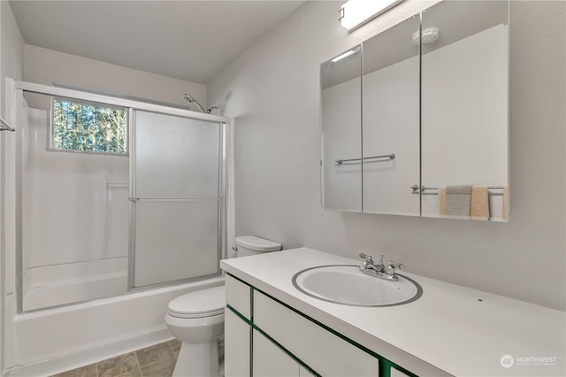 full bathroom with enclosed tub / shower combo, vanity, and toilet