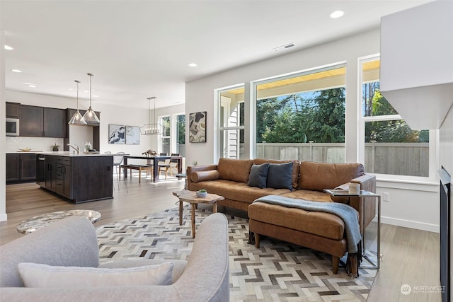 living room with sink and light hardwood / wood-style flooring