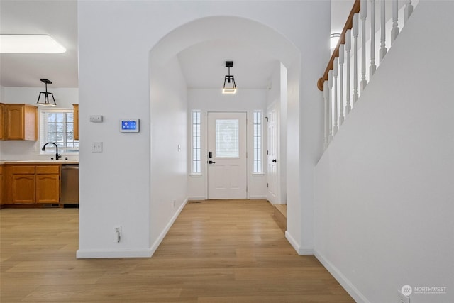 foyer entrance with sink and light hardwood / wood-style floors