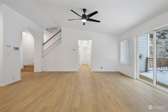 unfurnished living room with ceiling fan, vaulted ceiling, and light wood-type flooring