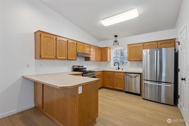 kitchen featuring vaulted ceiling, appliances with stainless steel finishes, sink, hanging light fixtures, and kitchen peninsula