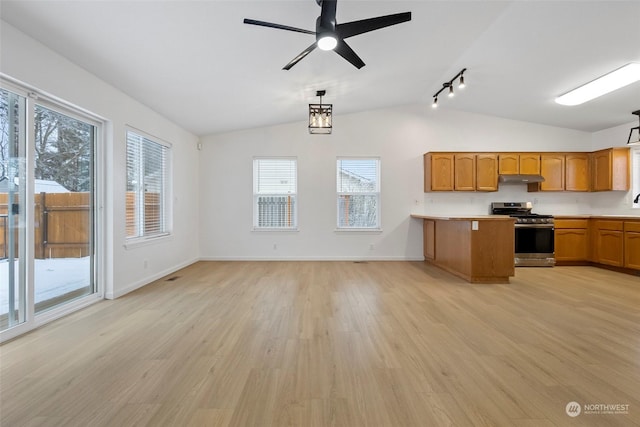 kitchen with stainless steel range with gas cooktop, lofted ceiling, hanging light fixtures, ceiling fan, and light wood-type flooring