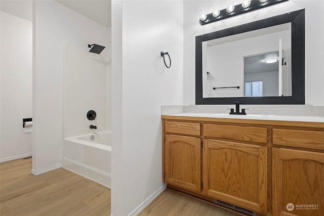 bathroom with vanity, hardwood / wood-style flooring, and bathtub / shower combination